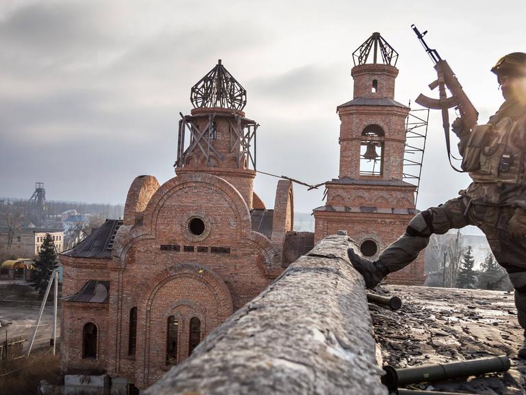 Soldat vor zerstörter Kirche im ukrainischen Dorf Pisky.