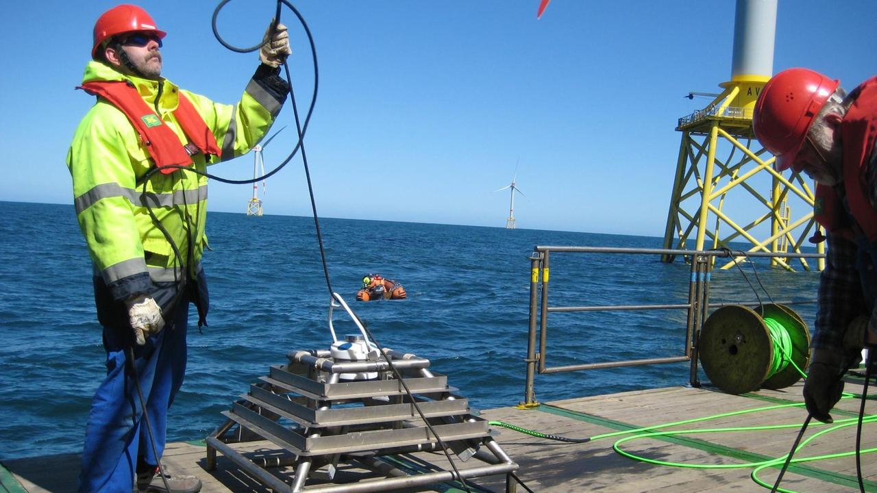 Arbeiter an Bord des BSH Schiffs Atair bereiten in der Nordsee das Absetzen einer Messsonde auf dem Meeresgrund vor