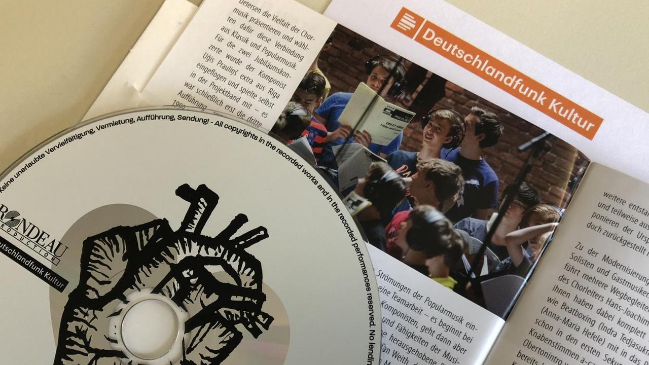 Auf dem aufgeschlagenen Cover liegt die CD. Auf dem aufgeschlagenen Cover liegt die CD.