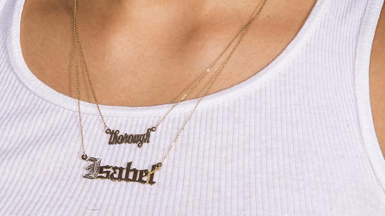 Eine Halskette mit einem Anhänger, mit dem Wort "Thorough" Eine Halskette mit einem Anhänger, mit dem Wort "Thorough"