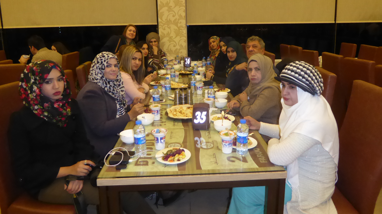 Najem Wali mit den Teilnehmerinnen des "Creative Writing"-Workshop in einem Restaurant.