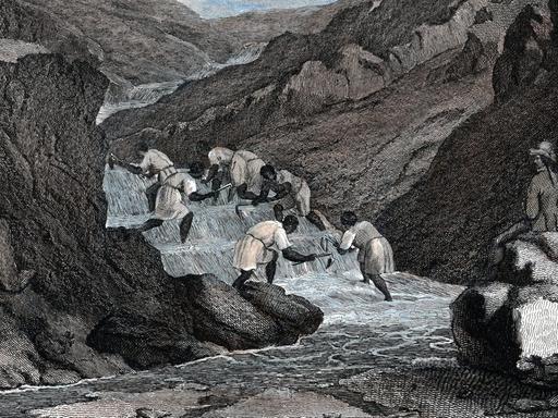 Die Zeichnung von 1814 zeigt Sklaven, die in einem Fluss Gold waschen. An der Seite sitzt ein Mann mit einer Peitsche.