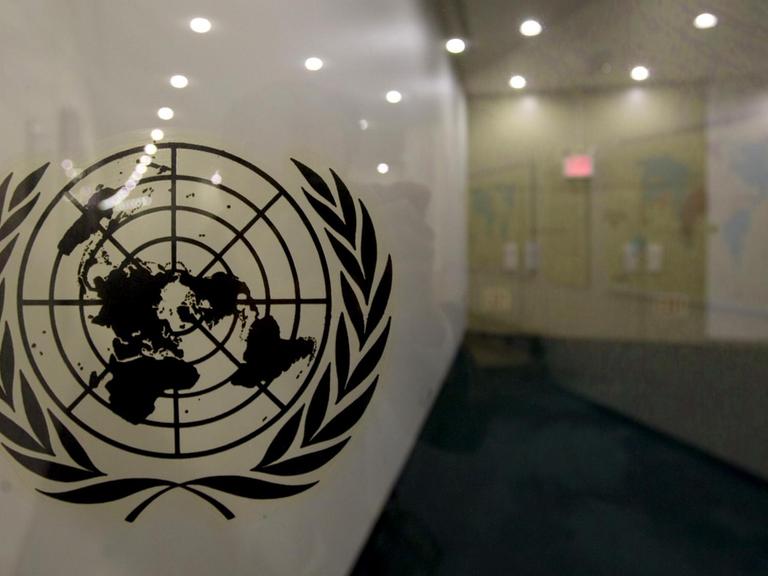 Das Logo der Vereinten Nationen auf einer Glasscheibe in den Räumlichkeiten der Vereinten Nationen in New York