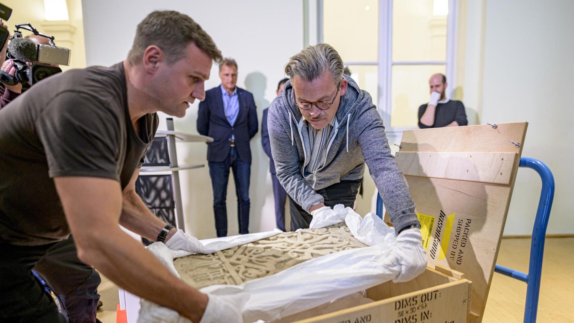 Das Foto zeigt Mitarbeiter des Museums für Kunst und Gewerbe, die ein Marmorpaneel aus dem 12. Jahrhundert einpacken. Das Foto zeigt Mitarbeiter des Museums für Kunst und Gewerbe, die ein Marmorpaneel aus dem 12. Jahrhundert einpacken.