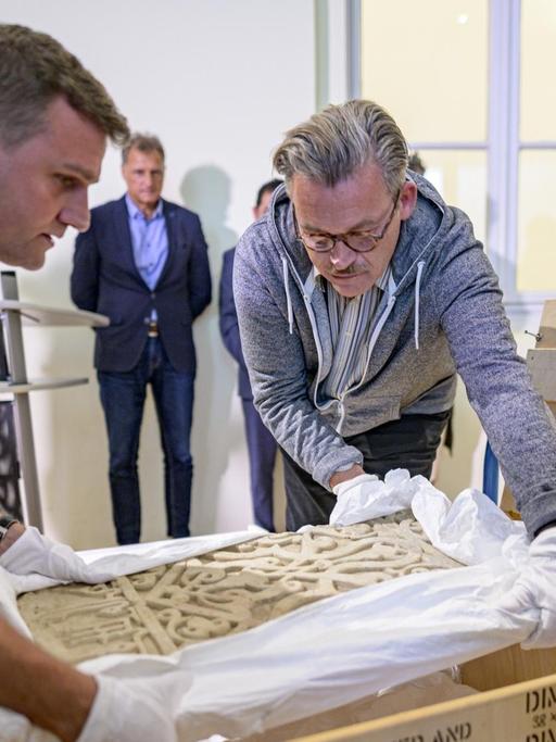 Das Foto zeigt Mitarbeiter des Museums für Kunst und Gewerbe, die ein Marmorpaneel aus dem 12. Jahrhundert einpacken.