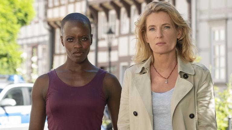 Florence Kasumba steht neben Maria Furtwängler. Beide stehen vor dem "Tatort"-Logo. Florence Kasumba steht neben Maria Furtwängler. Beide stehen vor dem "Tatort"-Logo.