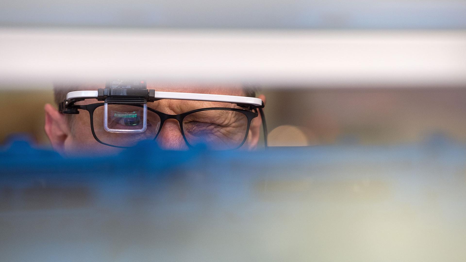 Ein Mann schaut am 26.04.2016 auf der Hannover Messe in Hannover (Niedersachsen) am Stand von Konica Minolta durch eine Datenbrille zur Unterstützung von Produktions- und Lagerprozessen. Die Industriemesse geht vom 24.04.2016 bis zum 29.04.2016. Foto: Sebastian Gollnow/dpa Ein Mann schaut am 26.04.2016 auf der Hannover Messe in Hannover (Niedersachsen) am Stand von Konica Minolta durch eine Datenbrille zur Unterstützung von Produktions- und Lagerprozessen. Die Industriemesse geht vom 24.04.2016 bis zum 29.04.2016. Foto: Sebastian Gollnow/dpa