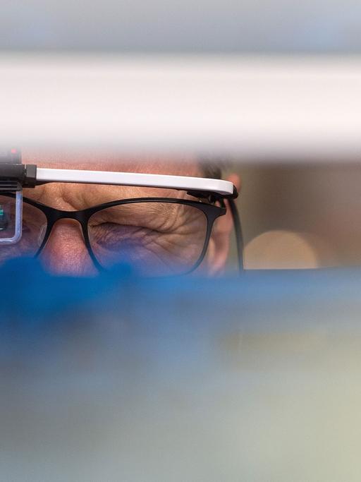 Ein Mann schaut am 26.04.2016 auf der Hannover Messe in Hannover (Niedersachsen) am Stand von Konica Minolta durch eine Datenbrille zur Unterstützung von Produktions- und Lagerprozessen. Die Industriemesse geht vom 24.04.2016 bis zum 29.04.2016. Foto: Sebastian Gollnow/dpa