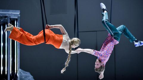 Auf dem Bild: Susanne-Marie Wrage und Paul Grill hängen akrobatisch von der Decke und halten sich an den Händen.