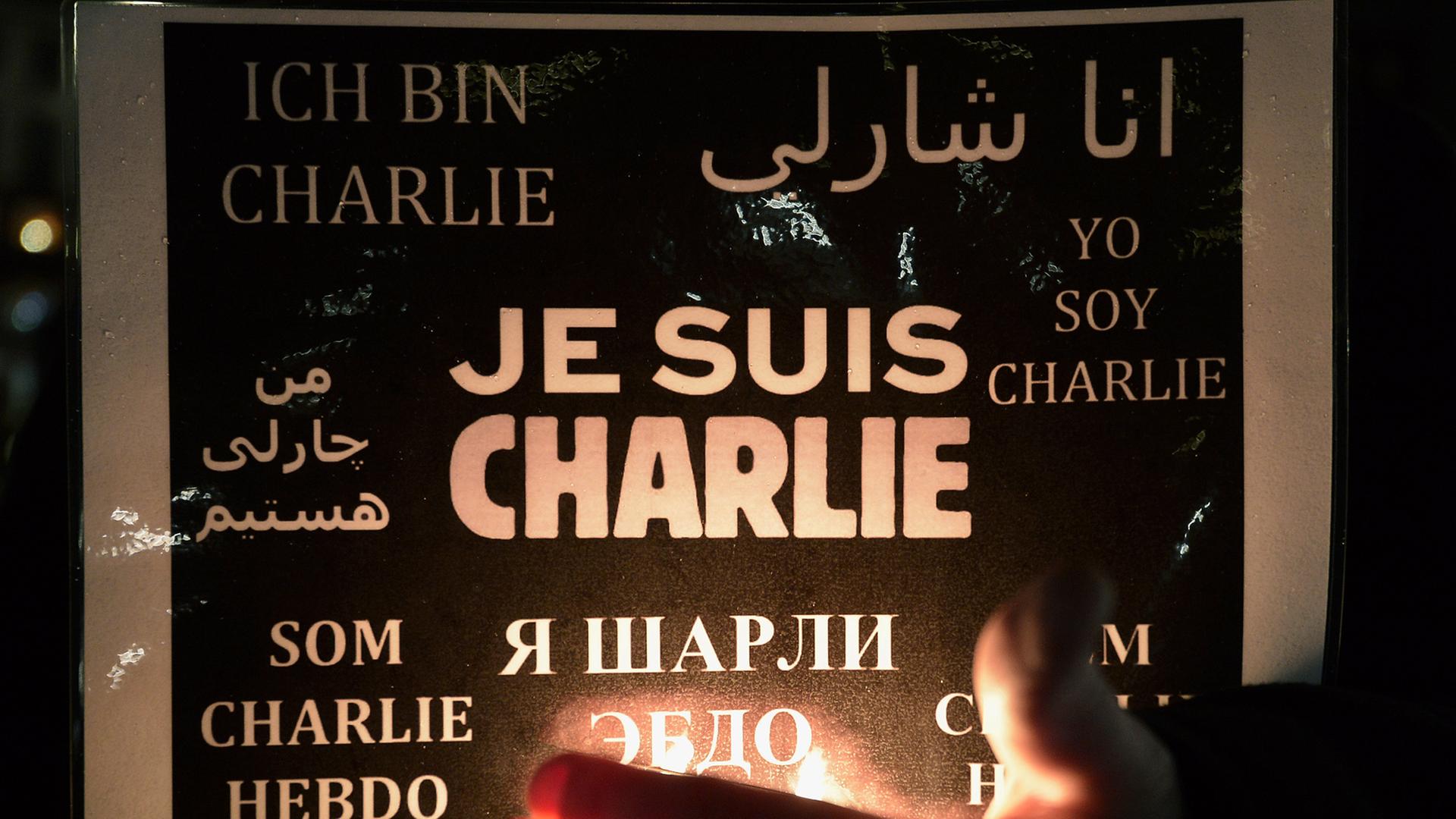 Eine Frau hält ein Poster mit einer Solidaritätsbekundung für "Charlie Hebdo" hoch Eine Frau hält ein Poster mit einer Solidaritätsbekundung für "Charlie Hebdo" hoch