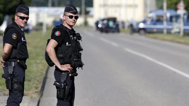 Zwei Polizisten stehen vor der Gasfabrik in Saint-Quentin-Fallavier.