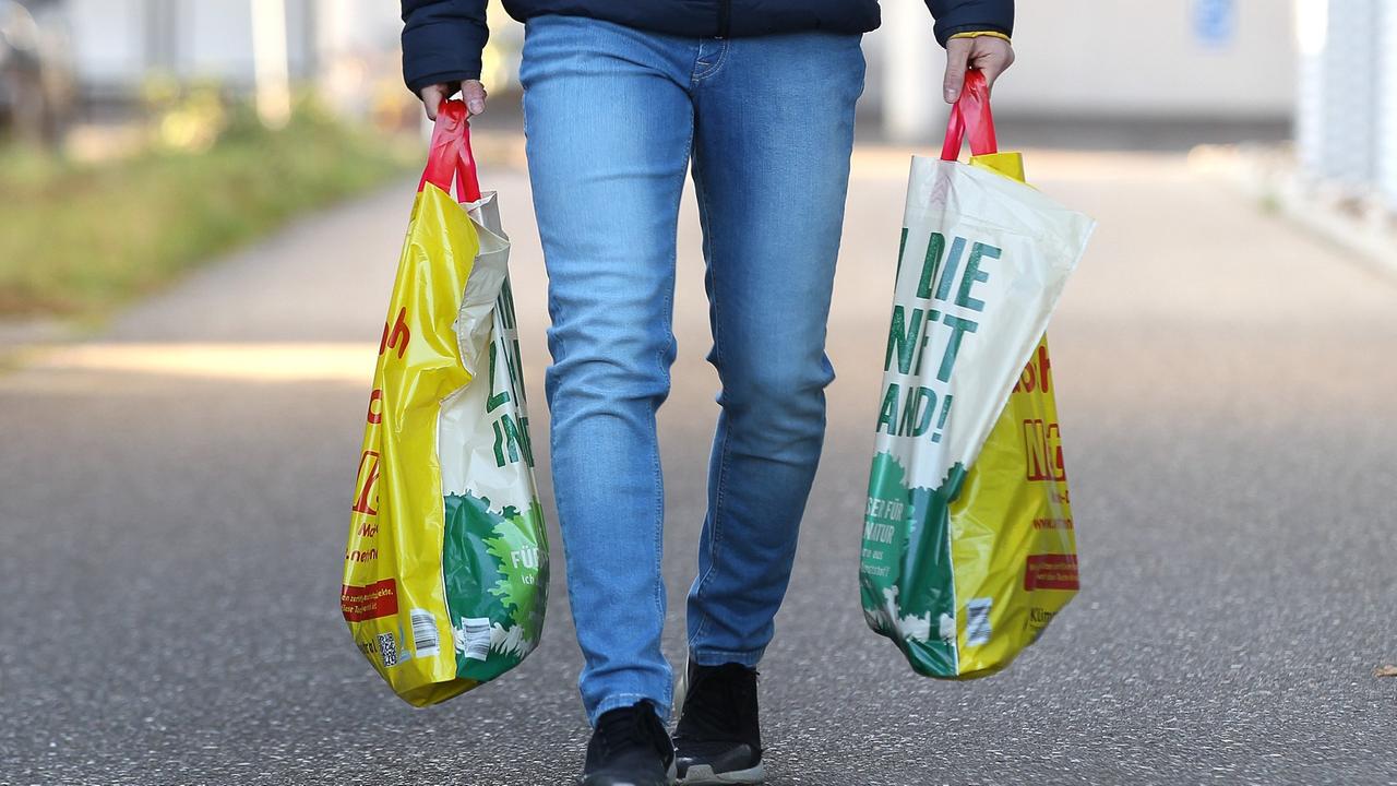 Zwei Hände tragen Plastiktüten. Zwei Hände tragen Plastiktüten.