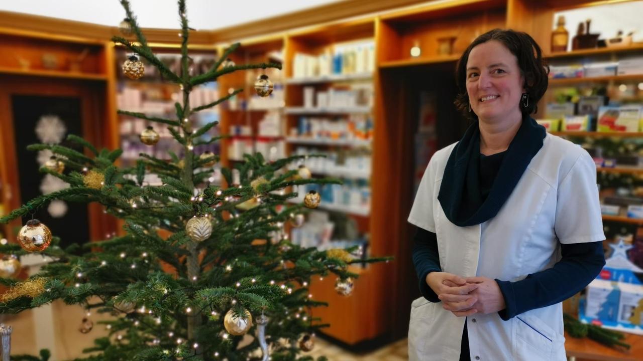 Inhaberin Sonja Willert in ihrer Apotheke in Eisleben neben einem Weihnachtsbaum