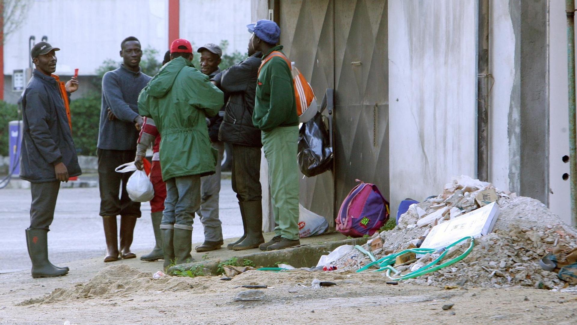Migranten aus Afrika warten darauf, als Erntehelfer auf den Zitrusfeldern in Gioia Tauro in Kalabrien eingesetzt zu werden. In der Landwirtschaft Süditaliens schuften viele Flüchtlinge für einen Hungerlohn. Migranten aus Afrika warten darauf, als Erntehelfer auf den Zitrusfeldern in Gioia Tauro in Kalabrien eingesetzt zu werden. In der Landwirtschaft Süditaliens schuften viele Flüchtlinge für einen Hungerlohn.
