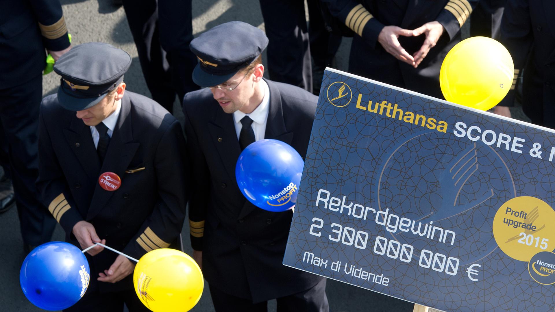 Piloten der Lufthansa protestieren am 02.04.2014 vor dem Flughafen von Frankfurt am Main (Hessen). Sie halten Ballons und ein Plakat in Händen, das auf das Lufthansa-Sparprogramm Score anspielt. Piloten der Lufthansa protestieren am 02.04.2014 vor dem Flughafen von Frankfurt am Main (Hessen). Sie halten Ballons und ein Plakat in Händen, das auf das Lufthansa-Sparprogramm Score anspielt.