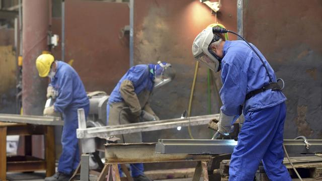 Metallarbeiter arbeiten an Eisenteilen.