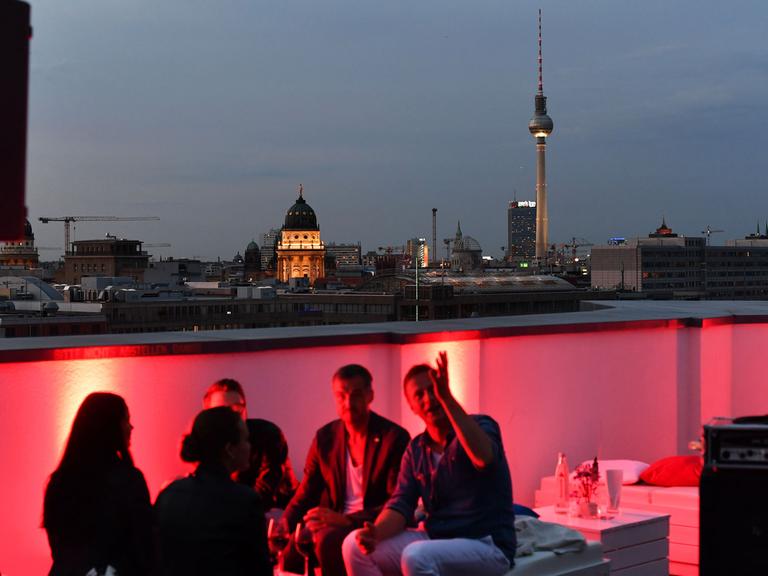 Gäste vor der Skyline von Berlin in der Skylounge vom EWerk in Berlin-Mitte