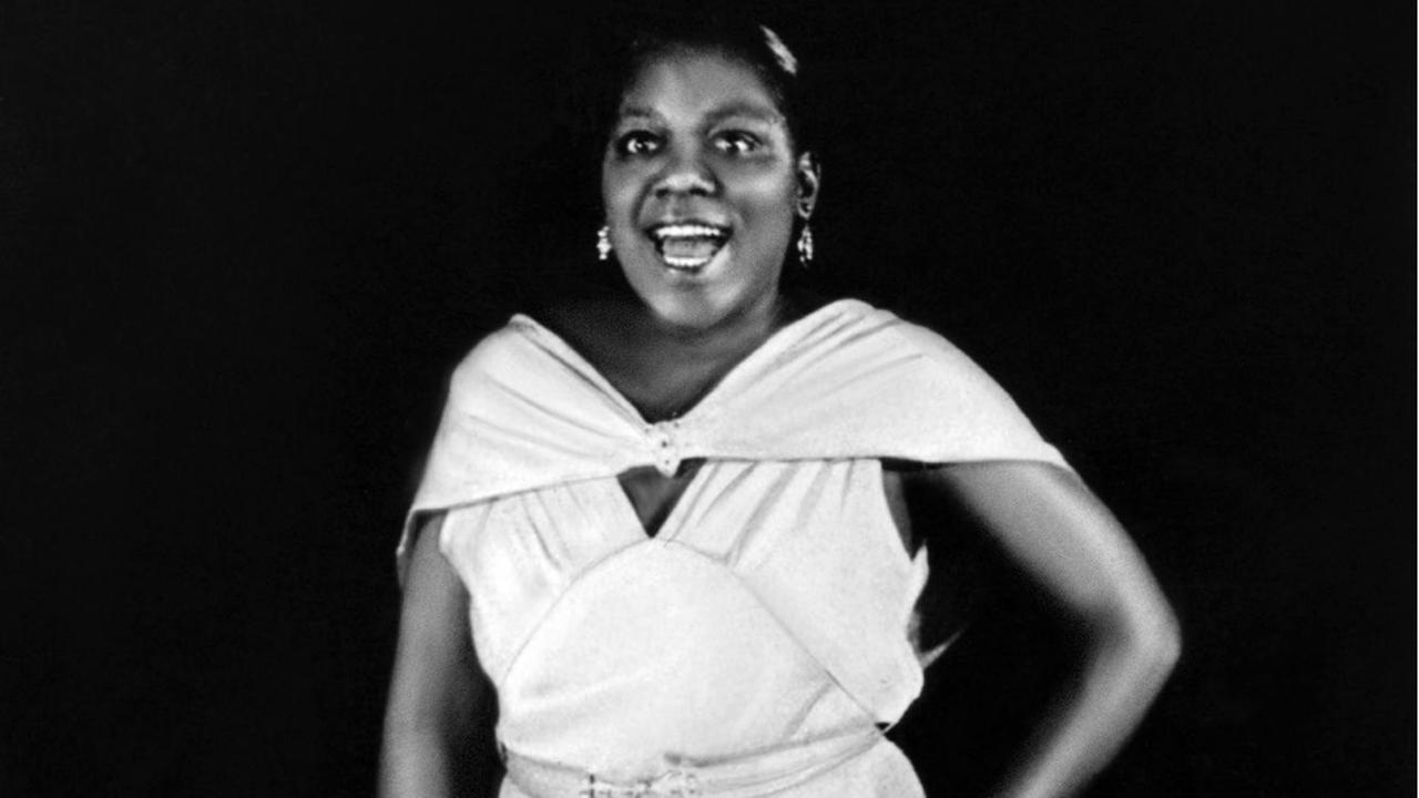 Bessie Smith halbnah, lächelnd, in einem weißen Kleid, fotografiert 1922 Bessie Smith halbnah, lächelnd, in einem weißen Kleid, fotografiert 1922
