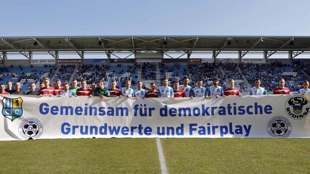Spieler halten ein Banner mit der Aufschrift "Gemeinsam für demokratische Grundwerde und Fairplay".