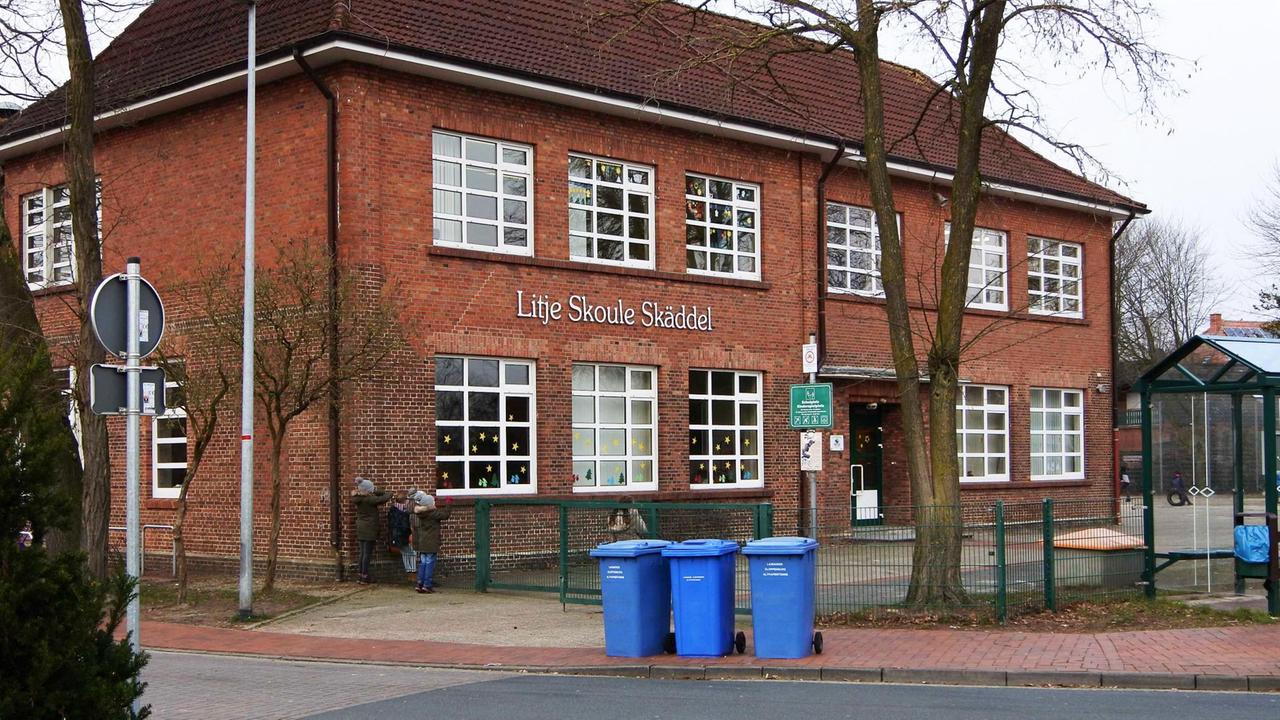 Eine Schule in Scharrel, auf der "Lütje Skoule Skäddel" steht
