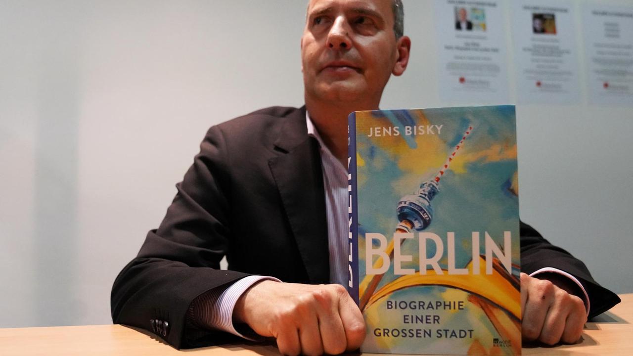 Jens Bisky hält sein Berlin-Buch in die Kamera
