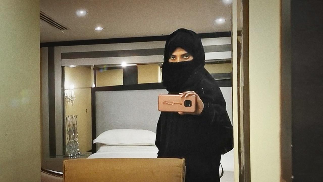 Filmstill aus "Saudi Runaway", eine schwarz verschleierte Frau macht ein Selfie von sich im Spiegel mit ihrem Telefon. Filmstill aus "Saudi Runaway", eine schwarz verschleierte Frau macht ein Selfie von sich im Spiegel mit ihrem Telefon.