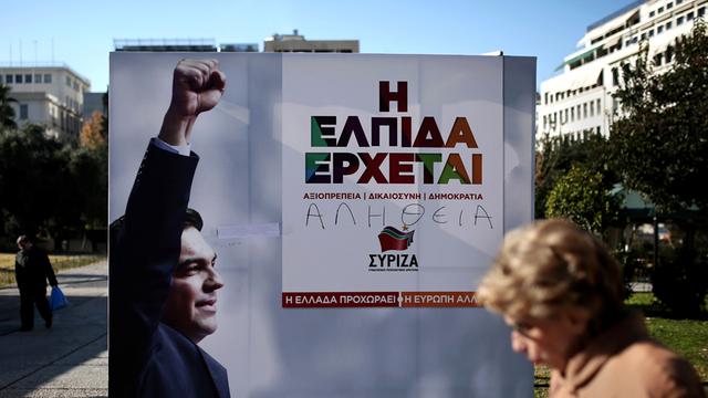 Eine Frau geht in Athen an einem Wahlplakat der griechischen Partei Syriza vorbei.