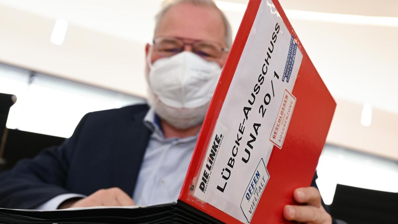 Der Abgeordnete Hermann Schaus (Die Linke) blickt zu Beginn der Sitzung des Lübcke-Untersuchungsausschusses im hessischen Landtag in seinem Aktenordner mit der Aufschrift "Lübcke-Ausschuss UNA 20/1". In seiner zweiten öffentlichen Sitzung wird der Untersuchungsausschuss erneut Sachverständige anhören. Der Ausschuss soll die Rolle der hessischen Sicherheitsbehörden im Mordfall Walter Lübcke aufarbeiten. Der Kasseler Regierungspräsident war 2019 getötet worden. Der Abgeordnete Hermann Schaus (Die Linke) blickt zu Beginn der Sitzung des Lübcke-Untersuchungsausschusses im hessischen Landtag in seinem Aktenordner mit der Aufschrift "Lübcke-Ausschuss UNA 20/1". In seiner zweiten öffentlichen Sitzung wird der Untersuchungsausschuss erneut Sachverständige anhören. Der Ausschuss soll die Rolle der hessischen Sicherheitsbehörden im Mordfall Walter Lübcke aufarbeiten. Der Kasseler Regierungspräsident war 2019 getötet worden.