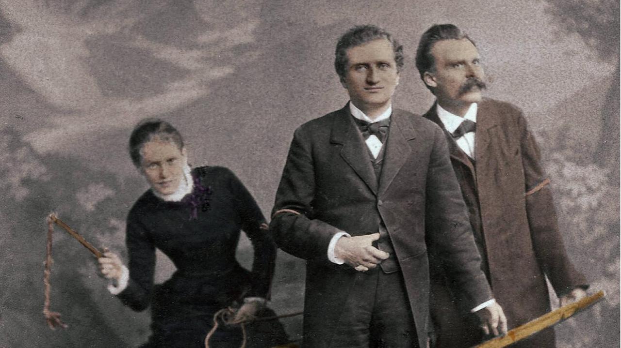 Paul Ree und Friedrich Nietzsche stehen wie Pferde vor einem Wagen, Lou Salomé schwingt im Hintergrund die Gerte. Paul Ree und Friedrich Nietzsche stehen wie Pferde vor einem Wagen, Lou Salomé schwingt im Hintergrund die Gerte.