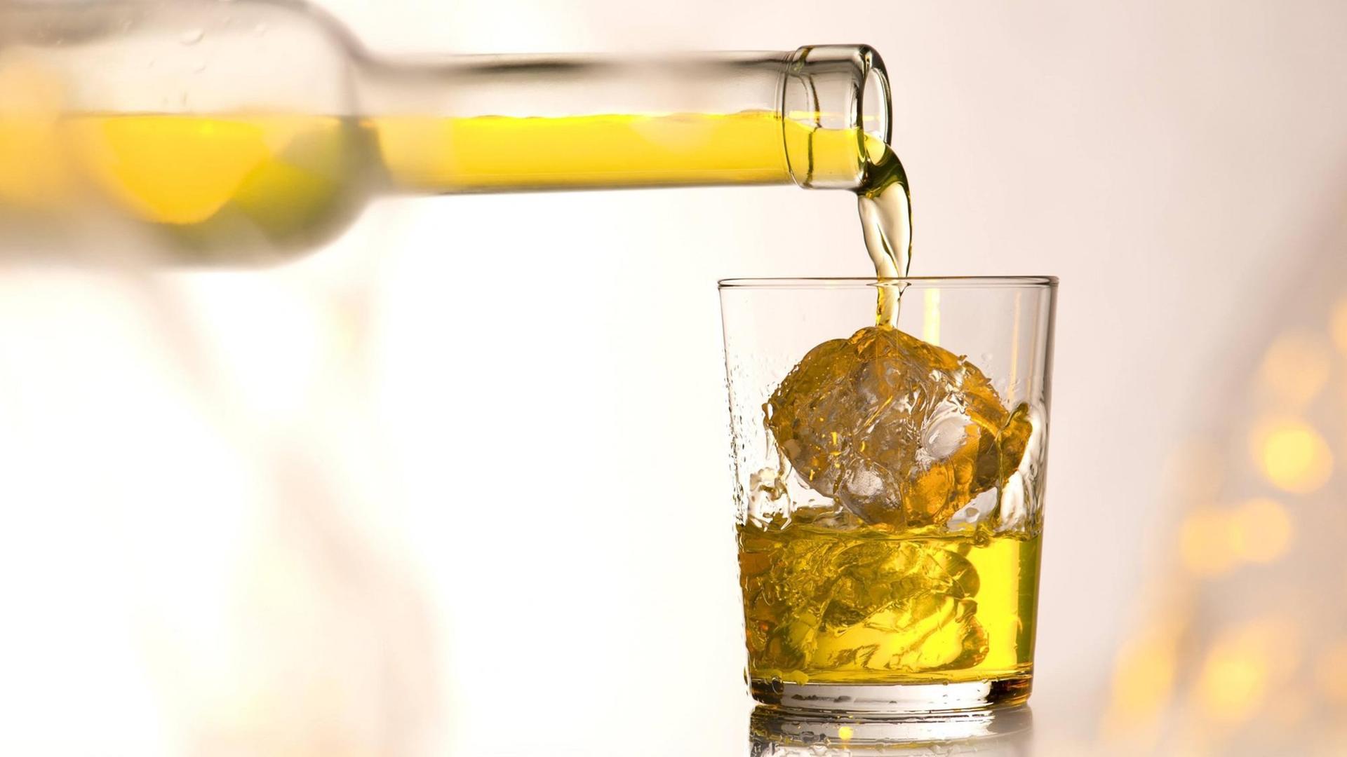 Whiskey in ein Glas mit Eiswürfeln. Whiskey in ein Glas mit Eiswürfeln.