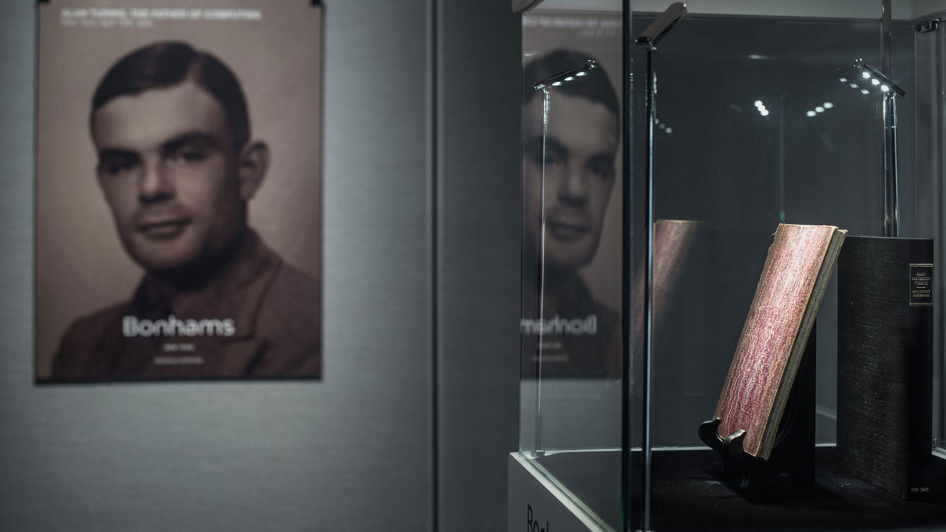 In einer Vitrine werden handschriftliche Notizen von Alan Turing (1912-1954) ausgestellt, im Hintergrund ein Plakat mit einem Foto des britischen Mathematikers. In einer Vitrine werden handschriftliche Notizen von Alan Turing (1912-1954) ausgestellt, im Hintergrund ein Plakat mit einem Foto des britischen Mathematikers.
