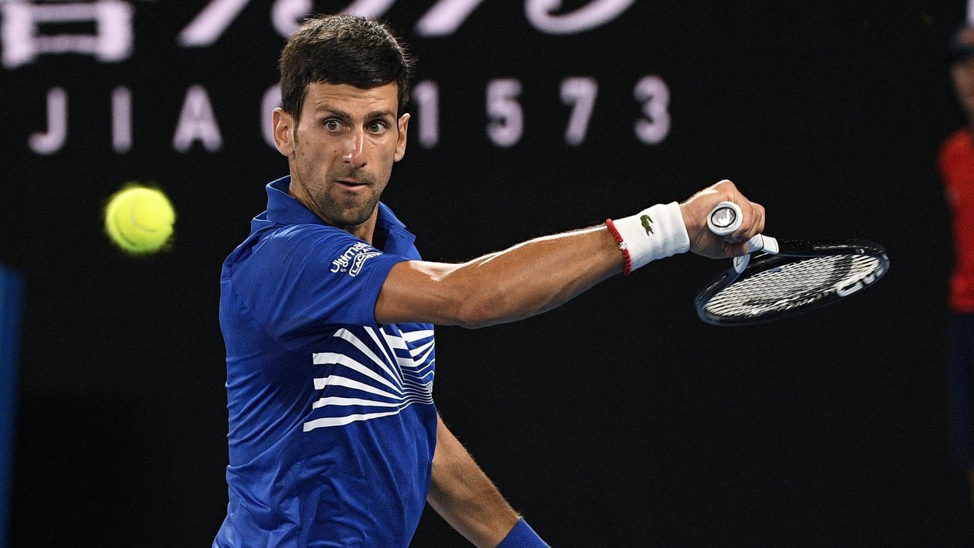 Tennisspieler Novak Djokovic schlägt im Finale der Australian Open einen Ball. Tennisspieler Novak Djokovic schlägt im Finale der Australian Open einen Ball.