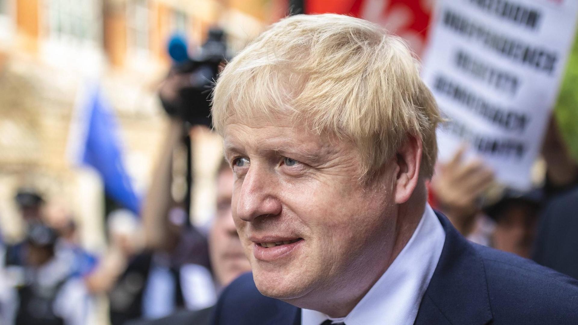 Der britische Politiker Boris Johnson blickt im Halbprofil zuversichtlich in Richtung seiner Anhänger. Der britische Politiker Boris Johnson blickt im Halbprofil zuversichtlich in Richtung seiner Anhänger.