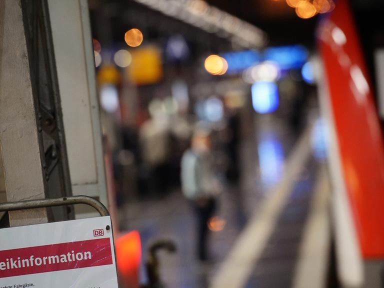 Ein Zug steht am Bahnsteig am Frankfurter Hauptbahnhof. Im Vordergrund ist ein Schild zu sehen mit der Aufschrift "Streikinformation".