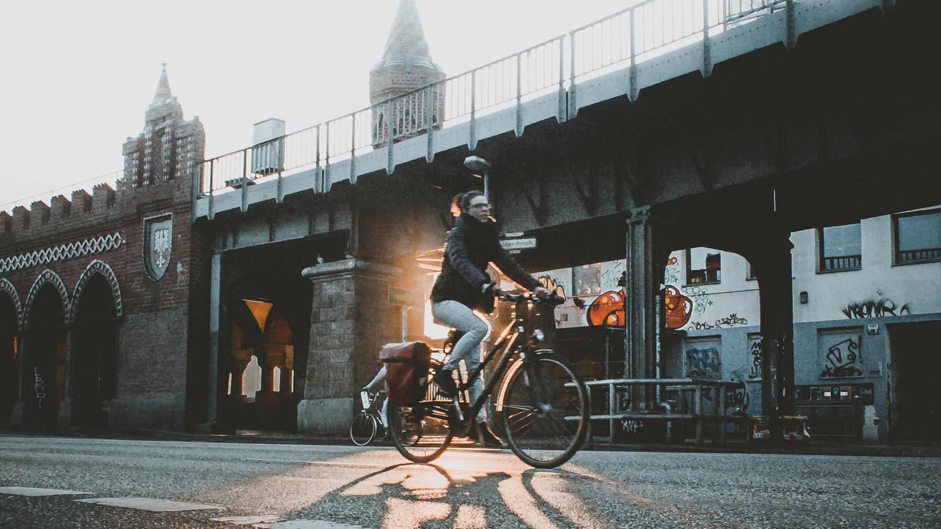 Eine Radfahrerin fährt in Berlin dei Oberbaumbrücke entlang. Eine Radfahrerin fährt in Berlin dei Oberbaumbrücke entlang.