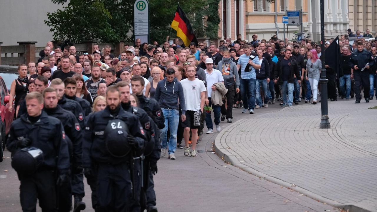 Der Demonstrationszug zieht durch die Stadt, ihm laufen Polizisten voraus. Der Demonstrationszug zieht durch die Stadt, ihm laufen Polizisten voraus.