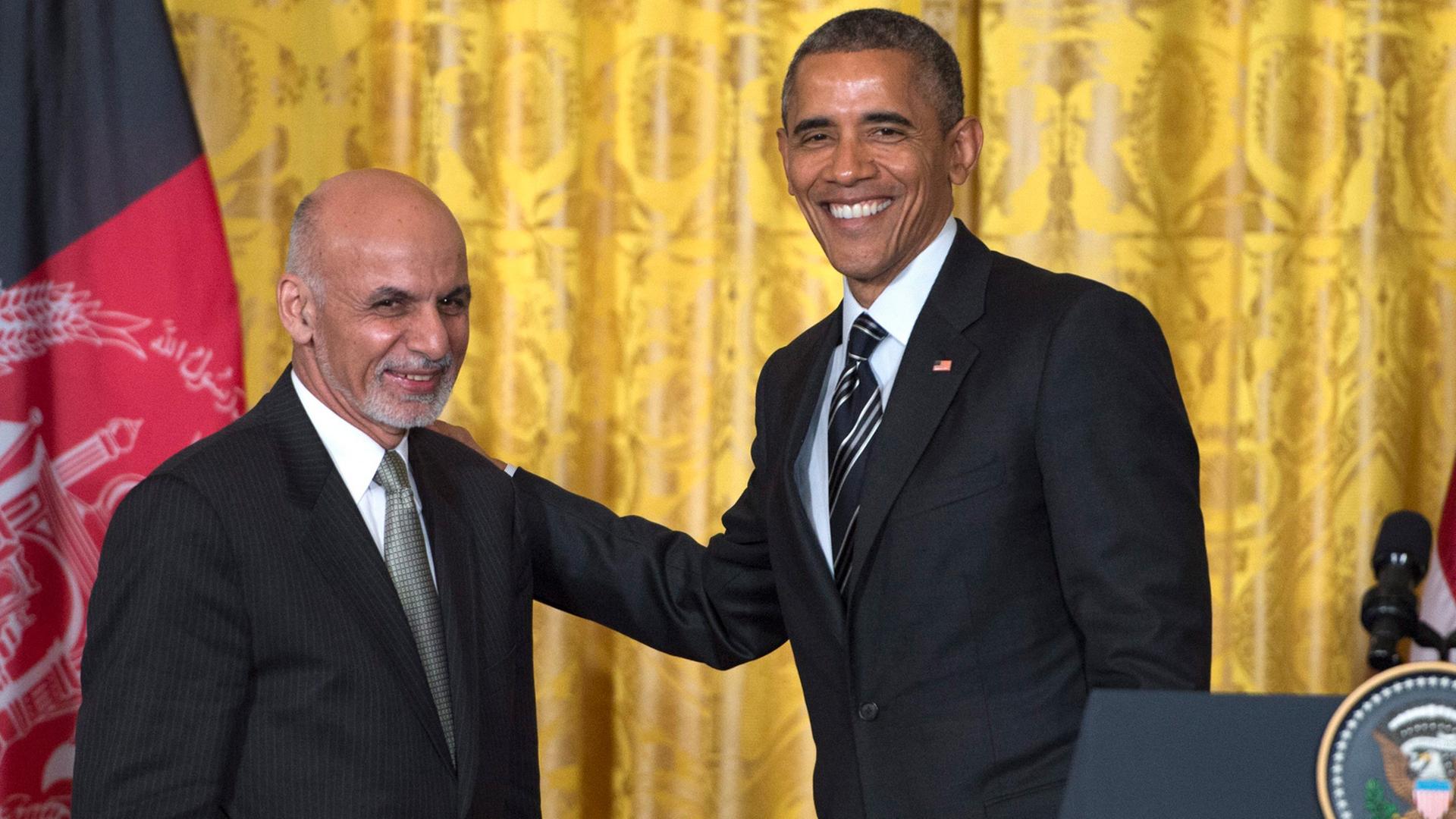 Im Pressekonferenzraum des Weißen Hauses: US-Präsident Obama und sein afghanischer Kollege Ghani lächeln in die Kameras, Obama hat seine Hand auf der Schulter Ghanis. 