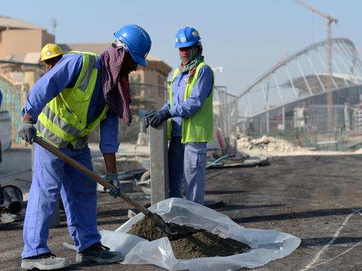 Gastarbeiter aus Indien und Bangladesch arbeiten vor dem Khalifa-Stadion in Doha, Katar. Im Vorfeld der WM 2022 in dem Golfstaat gab es immer wieder Berichte über die Ausbeutung von Migranten auf den Stadion-Baustellen