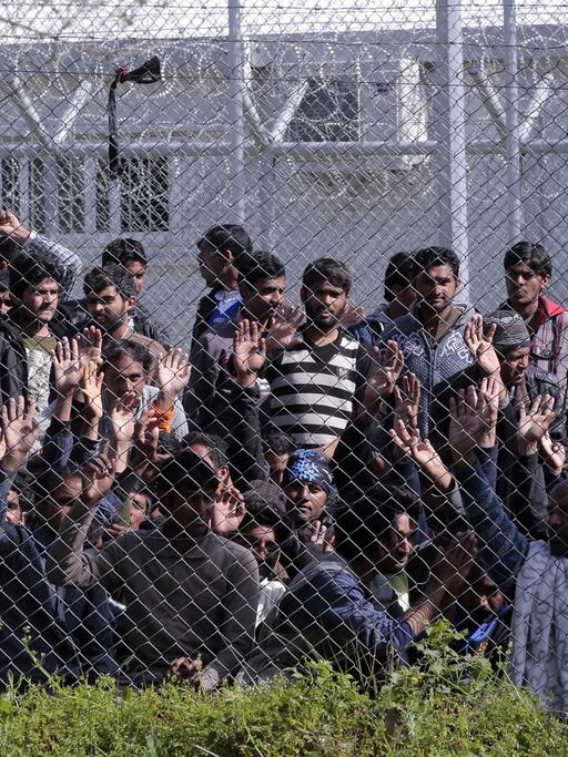 Menschen hinter einem Maschendrahtzaun auf der griechischen Insel Lesbos.