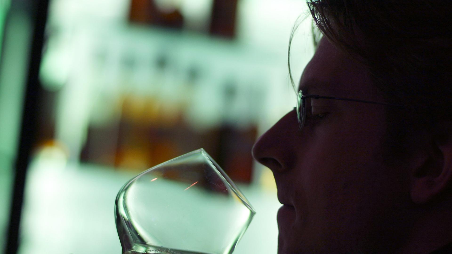 Ein Mann riecht an einem Glas Cognac in einer Hotelbar in München. Ein Mann riecht an einem Glas Cognac in einer Hotelbar in München.