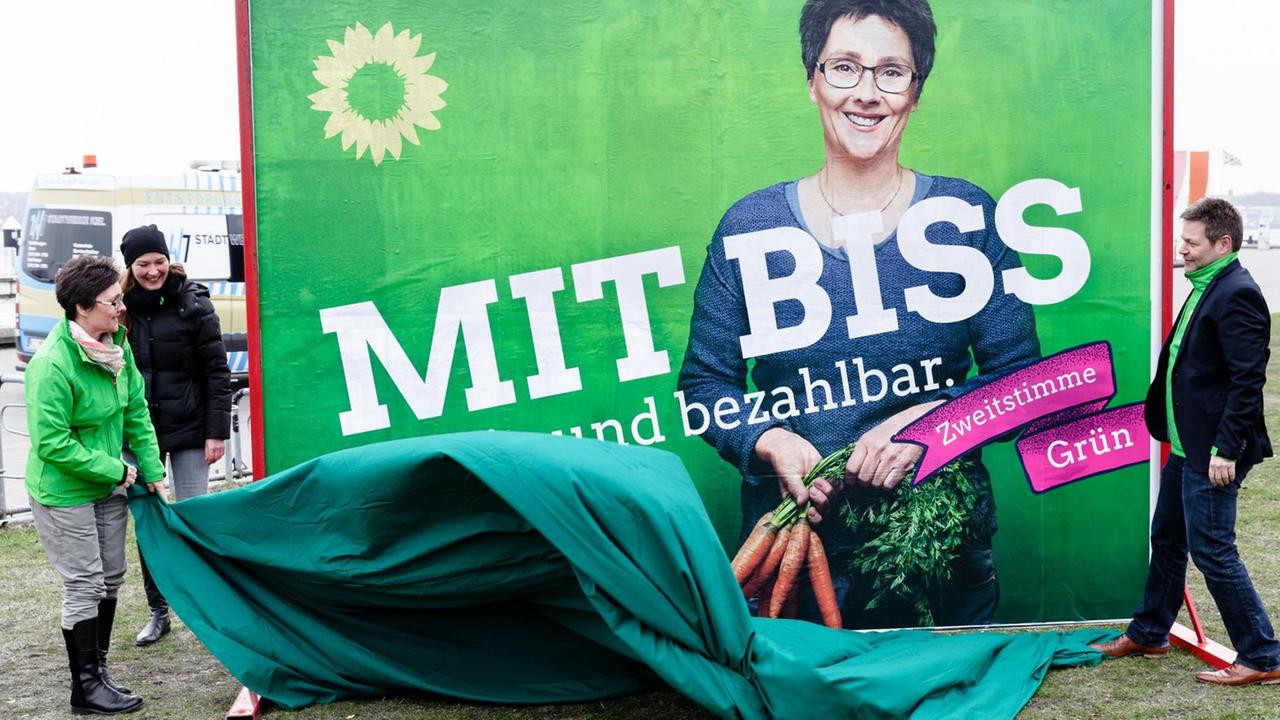 Monika Heinold (Grüne), Finanzministerin Schleswig-Holsteins und Spitzenkandidatin zur Landtagswahl, und Robert Habeck (Grüne), Umweltminister Schleswig-Holsteins, enthüllen am 08.03.2017 in Kiel (Schleswig-Holstein) ein Großplakat zur Landtagswahl mit der Aufschrift "Mit Biss für Bio und bezahlbar" . Foto: Markus Scholz/dpa | Verwendung weltweit Monika Heinold (Grüne), Finanzministerin Schleswig-Holsteins und Spitzenkandidatin zur Landtagswahl, und Robert Habeck (Grüne), Umweltminister Schleswig-Holsteins, enthüllen am 08.03.2017 in Kiel (Schleswig-Holstein) ein Großplakat zur Landtagswahl mit der Aufschrift "Mit Biss für Bio und bezahlbar" . Foto: Markus Scholz/dpa | Verwendung weltweit