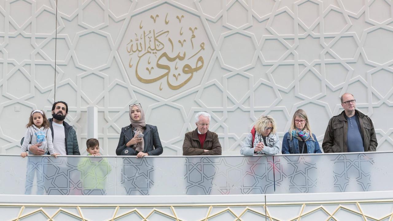 Mehrere Menschen blicken von einer Empore in die Zentralmoschee des muslimischen Verbandes Ditib in Köln-Ehrenfeld. Dort fand am 10. Oktober 2018 ein Tag der offenen Tür statt.