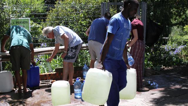 Bürger füllen am 15.12.2017 Wasserkanister an einer natürlichen Quelle in Kapstadts Vorort Newlands auf. In Südafrikas Touristen-Metropole Kapstadt wird die Wassserversorgung wegen einer anhaltenden Dürre nochmals drastisch reduziert.