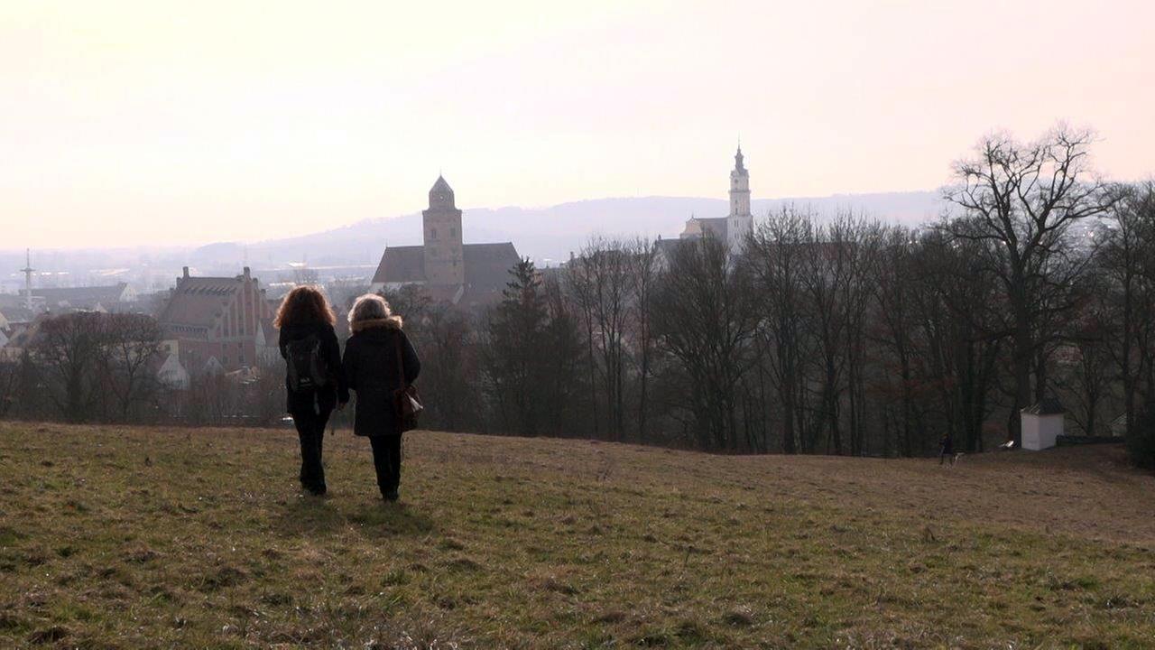 Zwei Schwestern stehen auf einer Anhöhe mit Blick auf die Stadt Donauwörth und das Kloster Heilig Kreuz. Zwei Schwestern stehen auf einer Anhöhe mit Blick auf die Stadt Donauwörth und das Kloster Heilig Kreuz.