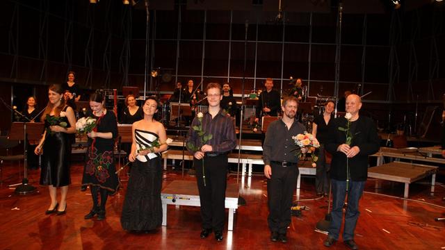 Das Ensemble Insomnio, mit Blumen in der Hand, steht beim Schlussapplaus auf und vor der Bühne des Kammermusiksaals