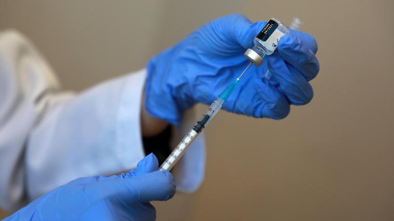 Palästina: Hände in Handschuhen beim Aufziehen einer Corona-Impfdosis Sputnik V