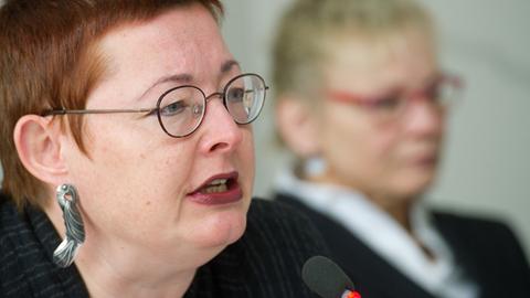Ein Porträt von Martina Weyrauch, der Leiterin der Brandenburgischen Landeszentrale für politische Bildung. Im Hintergrund ist unscharf eine Frau mit Brille zu sehen.