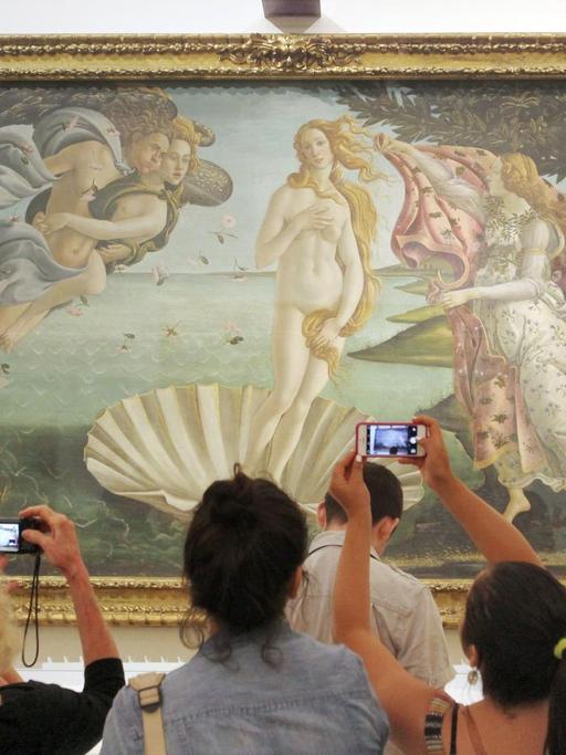 Besucher stehen vor dem Gemälde "Die Geburt der Venus" in den Uffizien in Florenz.