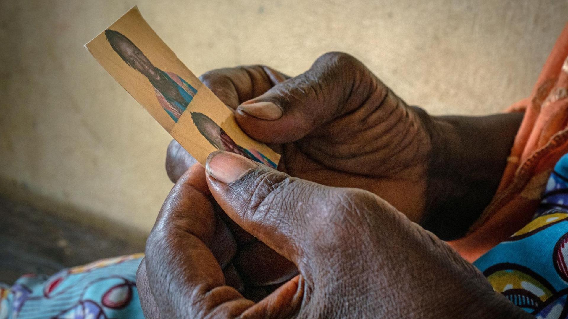 Eine Mutter in Conakry (Guineia) hält in ihren Händen das Foto ihres Sohnes, der die Reise nach Europa aus unbekannten Gründen nicht überlebte. Eine Mutter in Conakry (Guineia) hält in ihren Händen das Foto ihres Sohnes, der die Reise nach Europa aus unbekannten Gründen nicht überlebte.