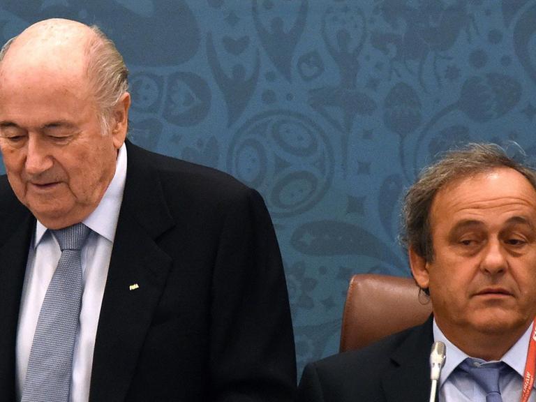 FIFA-Präsident Joseph Blatter (l) setzt sich neben UEFA-Präsident Michel Platini.